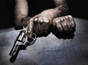A tattooed member of gangs holding a gun.